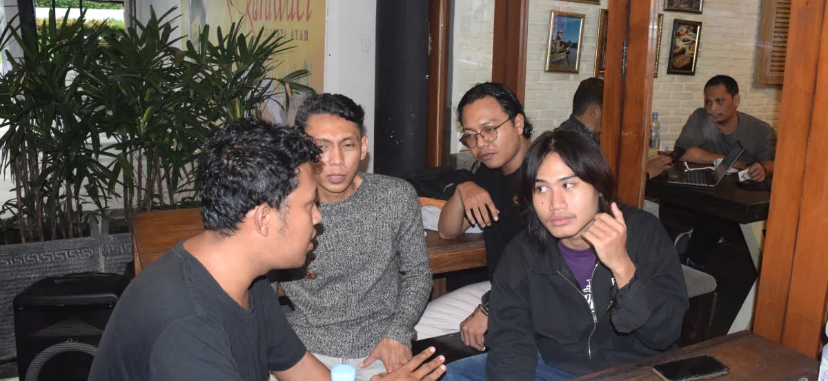 Beberapa peserta berbincang di sebuah meja dalam kegiatan komunitas.