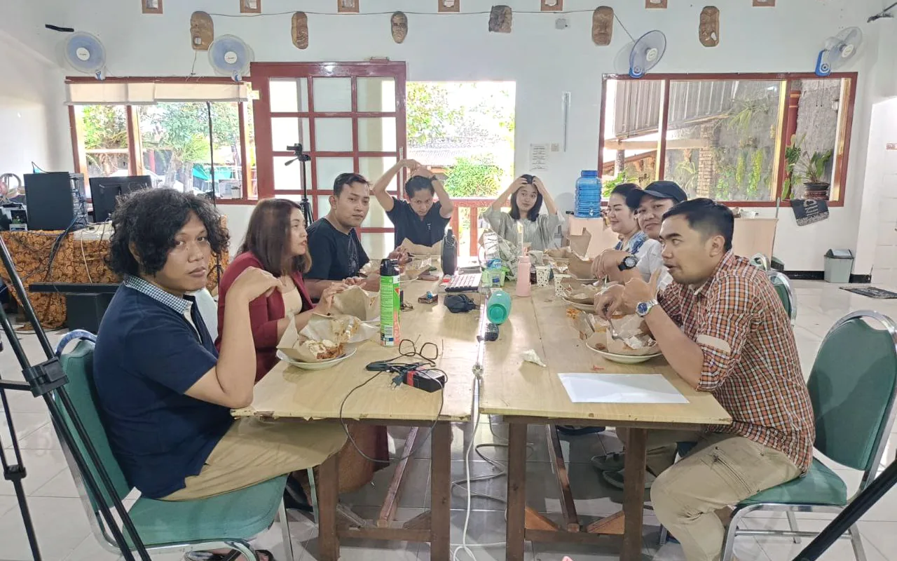 Sekelompok peserta duduk di satu meja dalam suasana diskusi komunitas.