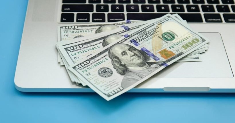 close-up-dollar-bills-laptop-money-making-concept_169016-26609